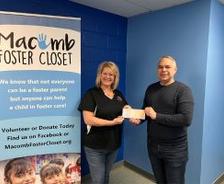 Groundworks holds a check with Macomb Forester Closet representative.