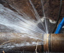 Water spraying from a large pipe in the ground