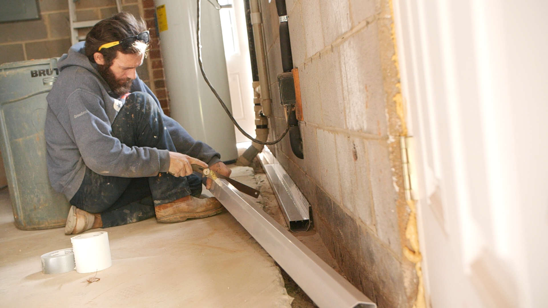 JES Foundation Repair crew installing interior drainage in basement