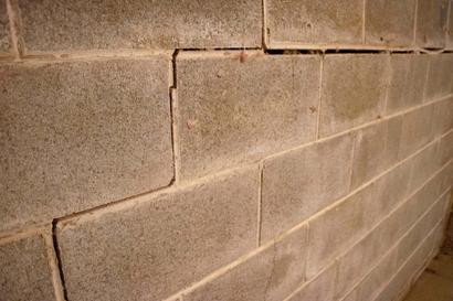 Stairstep crack in the cinderblock wall.