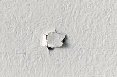 Drywall nail pop on interior wall.