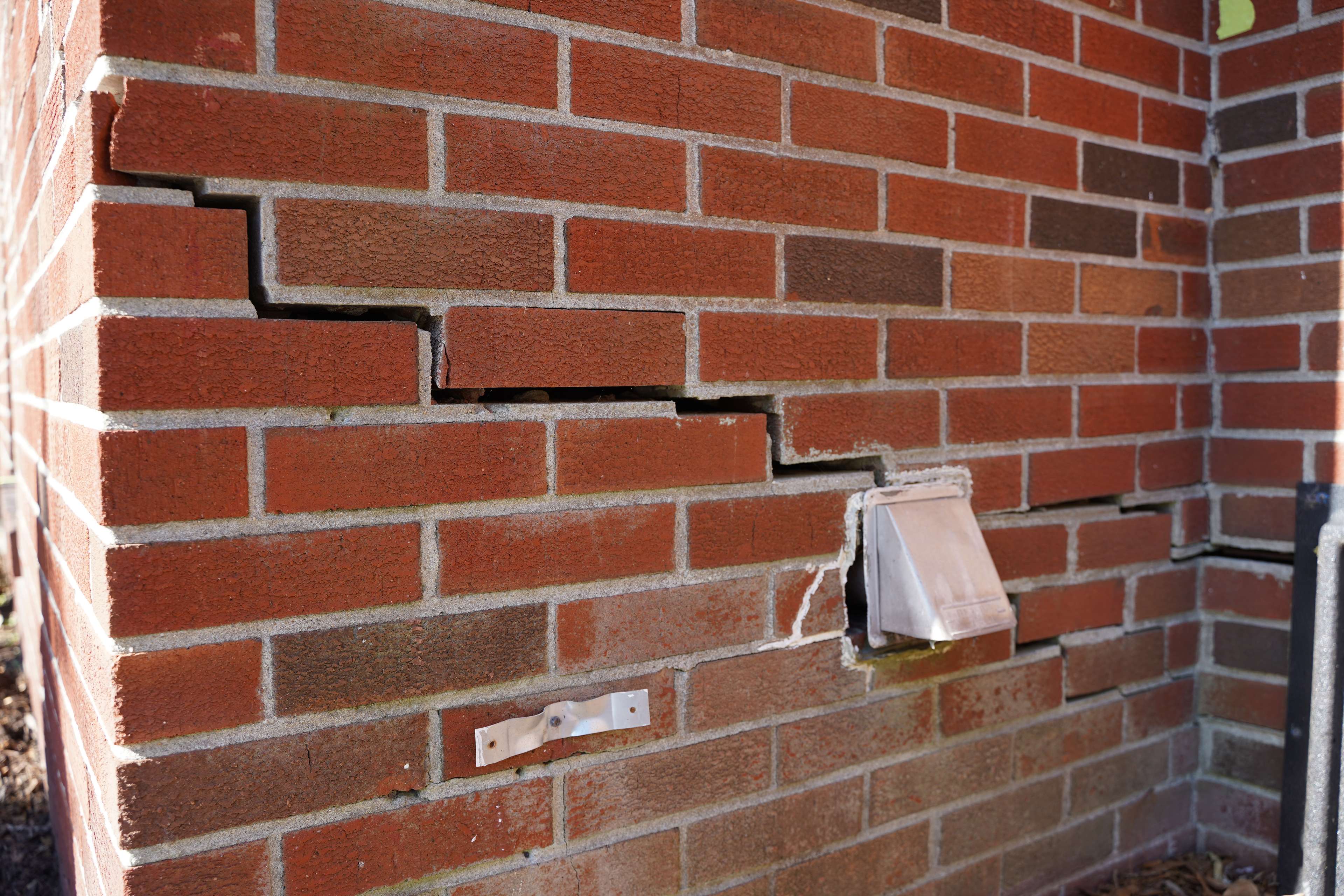 cracked brick in stair-step pattern on side of house