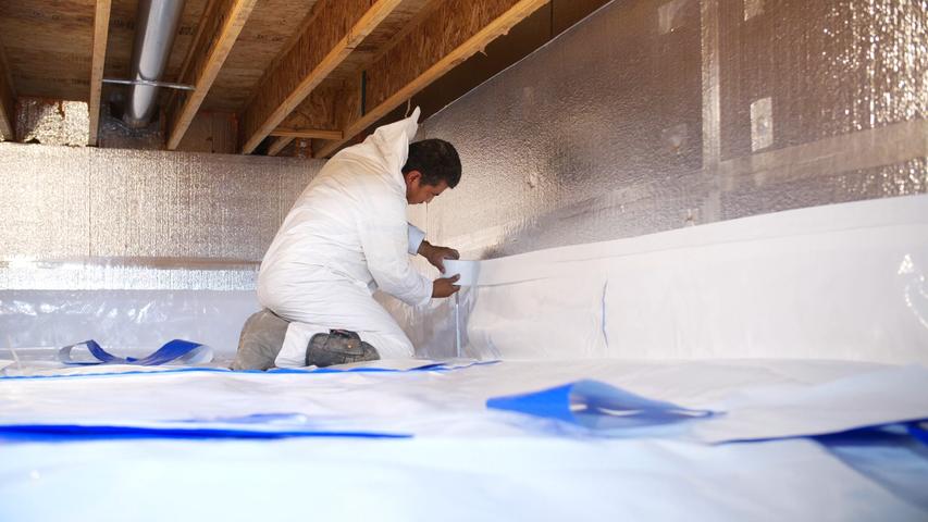 Crew member encapsulating crawl space of a home