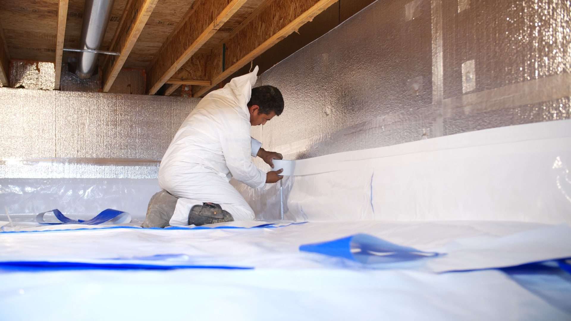 Dirty crawl space with falling insulation and debris.