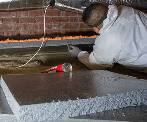 Crew installing thermal block in crawlspace