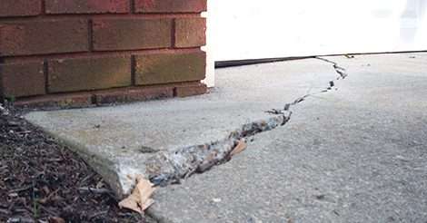 sinking concrete on the edge of a home with garage