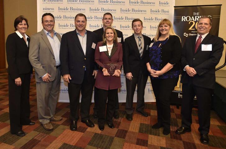 A group of people posing for a photo at a business event with a "Inside Business" banner in the background.