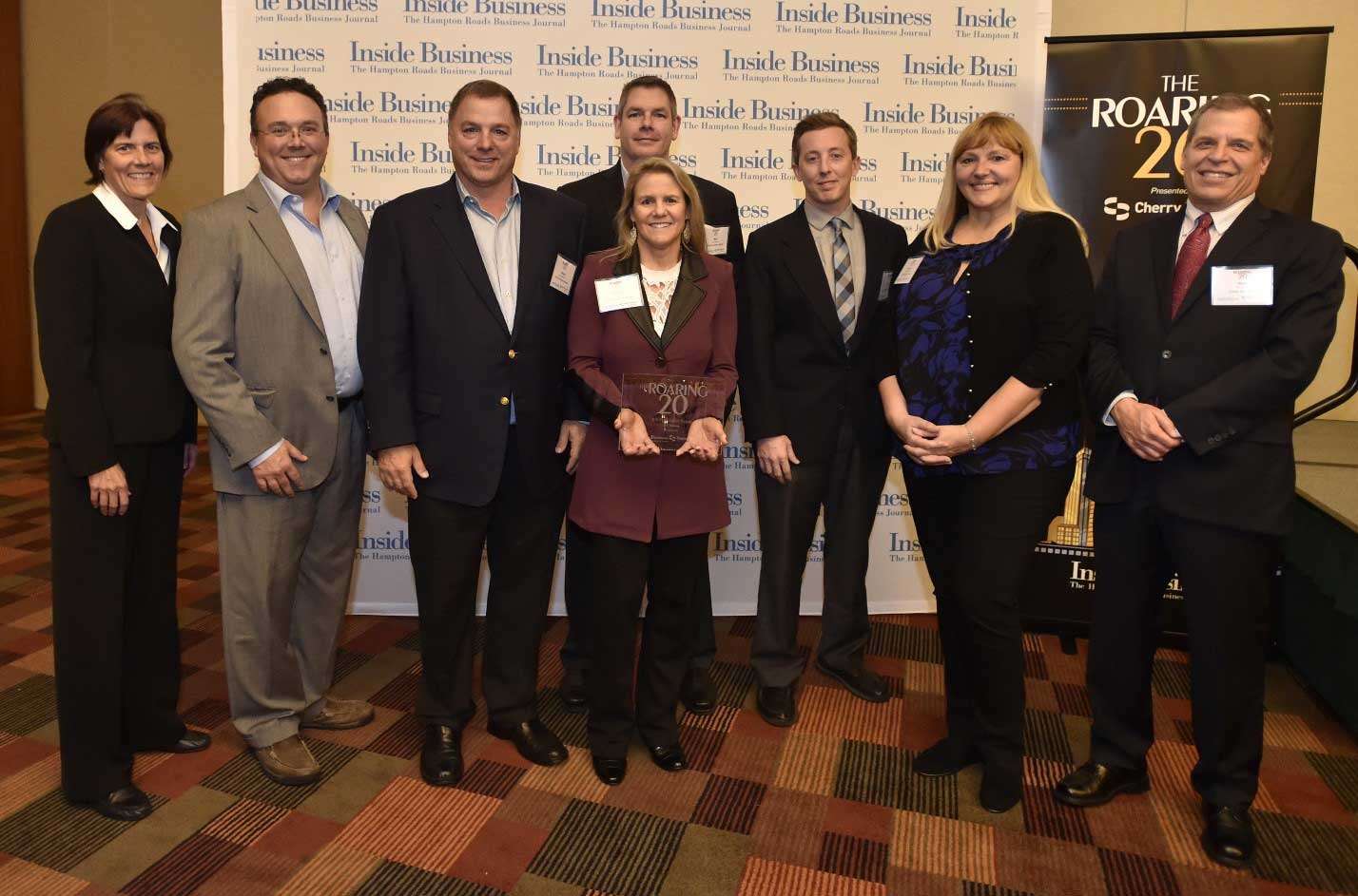 A group of people posing for a photo at a business event with a "Inside Business" banner in the background.