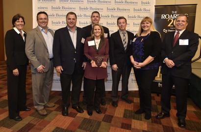 A group of people posing for a photo at a business event with a "Inside Business" banner in the background.