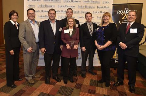 A group of people posing for a photo at a business event with a "Inside Business" banner in the background.