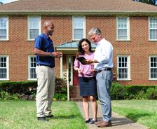 JES Foundation Repair inspector talking to two homeowners in front of their house