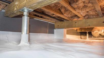 Crawl space with plastic vapor barrier, insulation, and support beams visible.