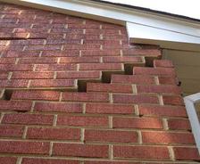 exterior brick wall with cracks and gaps, indicating foundation settlement