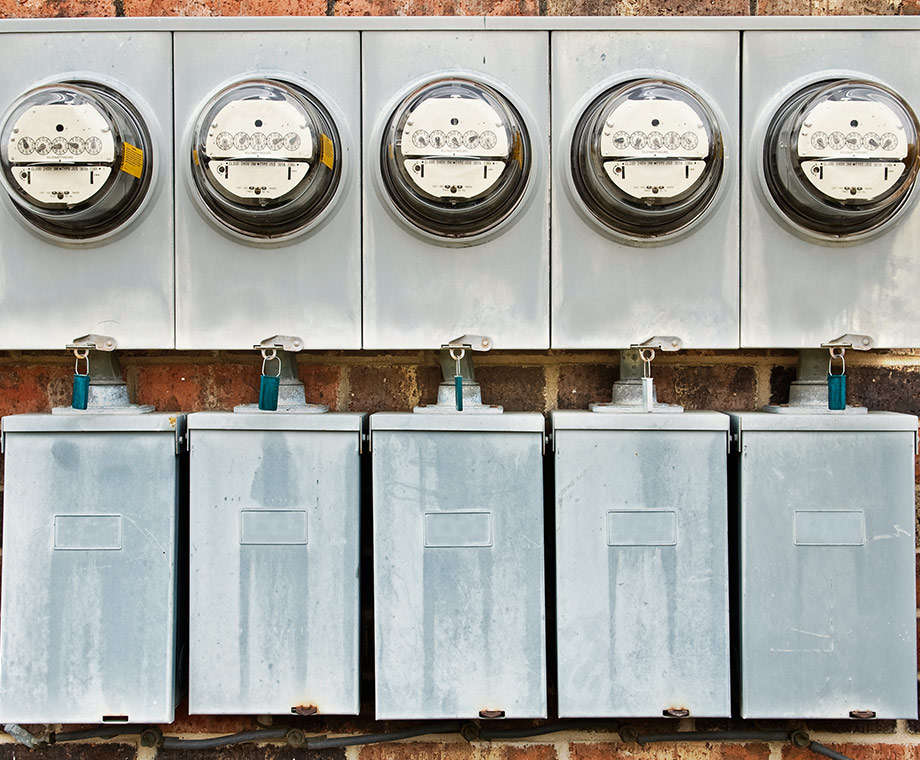 electric meters on the side of a building measuring usage resulting in high electric bills