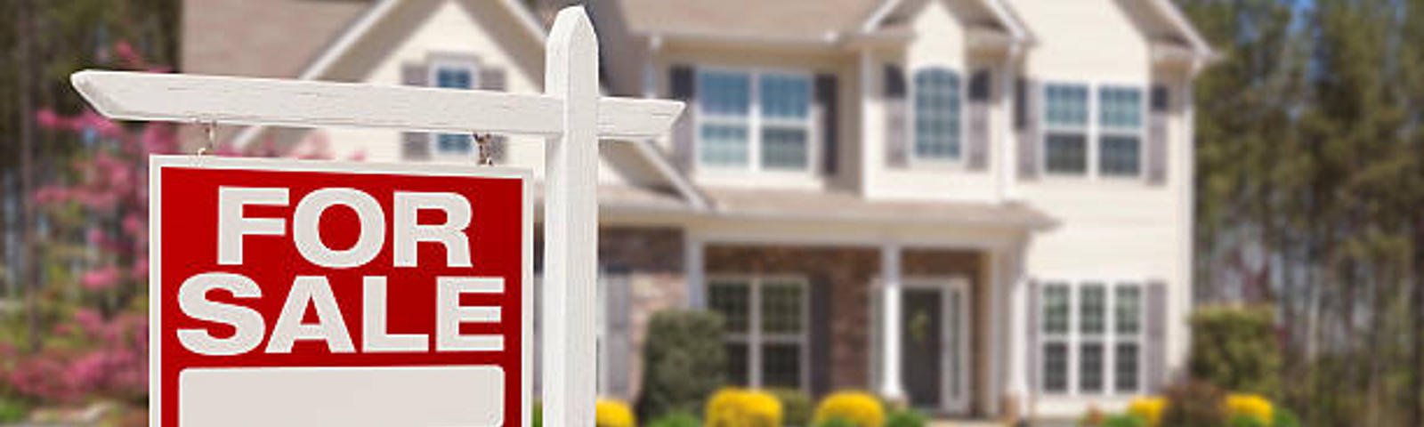 two-story house with for sale sign in yard
