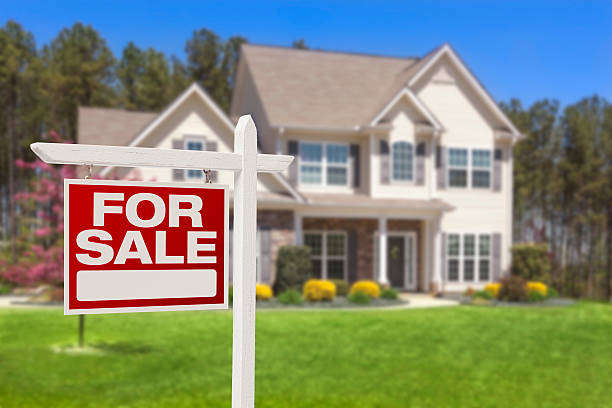 two-story house with for sale sign in yard