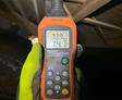 CFI performing crawl space inspection and measuring humidity