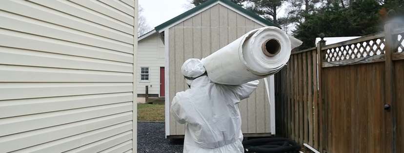 Crew carrying vapor barrier for installation