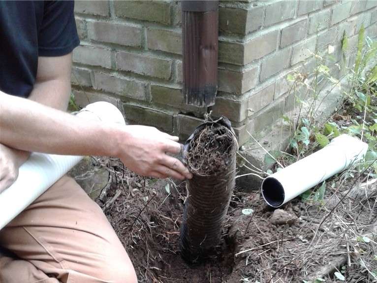 JES Repair inspector assessing clogged drainage on house exterior