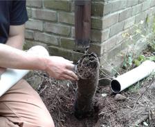 JES Repair inspector assessing clogged drainage on house exterior