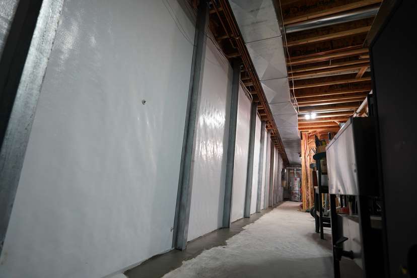 wall beams installed over a basement wall vapor barrier