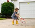 children playing in driveway with bushes in the background