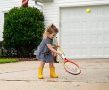 children playing in driveway with bushes in the background