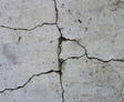 Close-up of cracked concrete floor with visible lines and uneven texture.