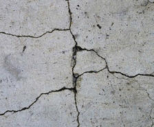 Close-up of cracked concrete floor with visible lines and uneven texture.