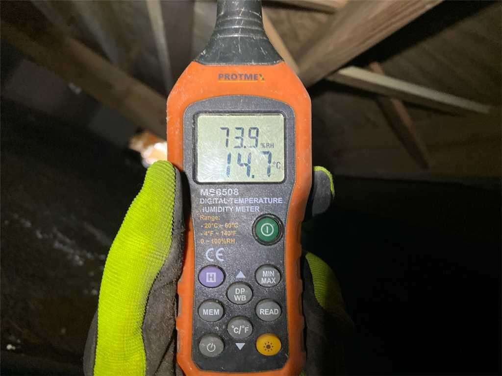 Moisture meter performing humidity test in crawl space.