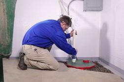 Crew installing sump pump in basement,
