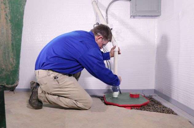 Crew installing sump pump in basement,