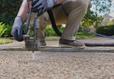 JES Foundation Repair crew injecting PolyRenewal polyurethane concrete lifting foam into a residential walkway.