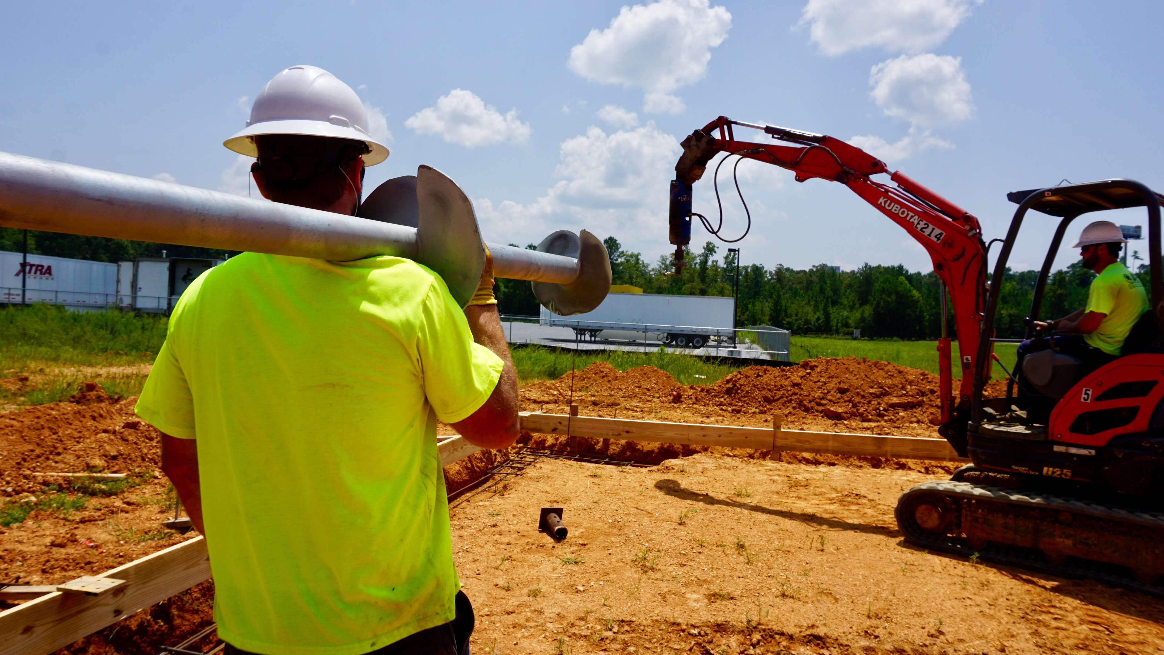 JES technician carrying a helical pier towards a job site.