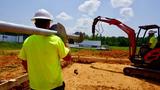 JES technician carrying a helical pier towards a job site.