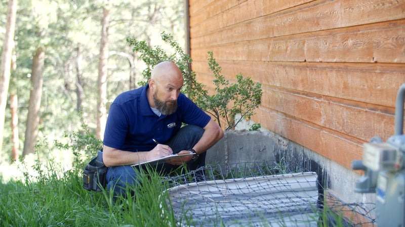JES Foundation Repair inspector assessing exterior foundation