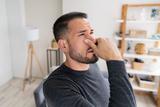man holding his nose because the crawl space smells musty