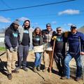Six JES Foundation Repair members in outdoor work clothes posing together in a sunny, open area.