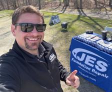 JES employee giving thumbs up next to the JES table at 2025 Frostbite Scramble sponsorship event