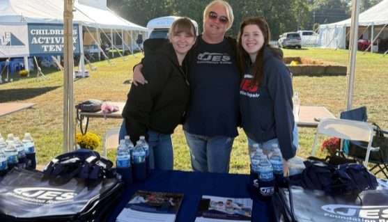 Three JES Foundation Repair crew members at sponsorship booth at Youth For Tomorrow's Country Fair & Auction