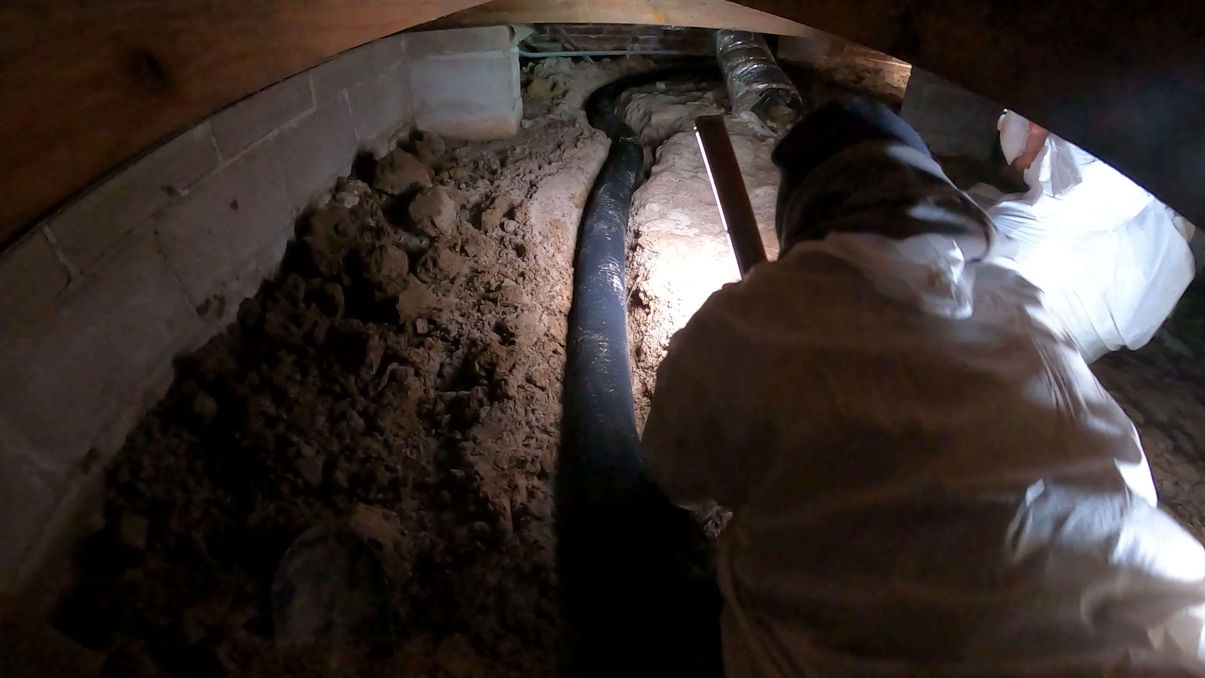 crew member installing crawl space drainage