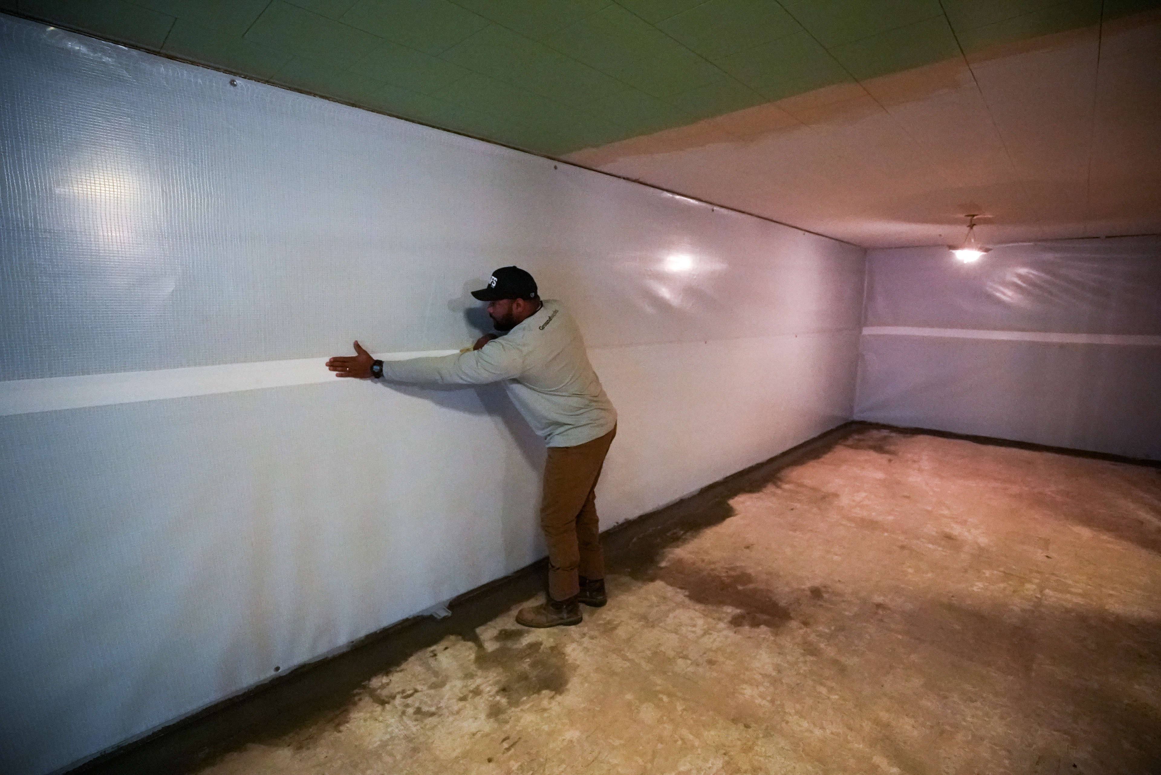 crew installing wallseal vapor barrier in basement