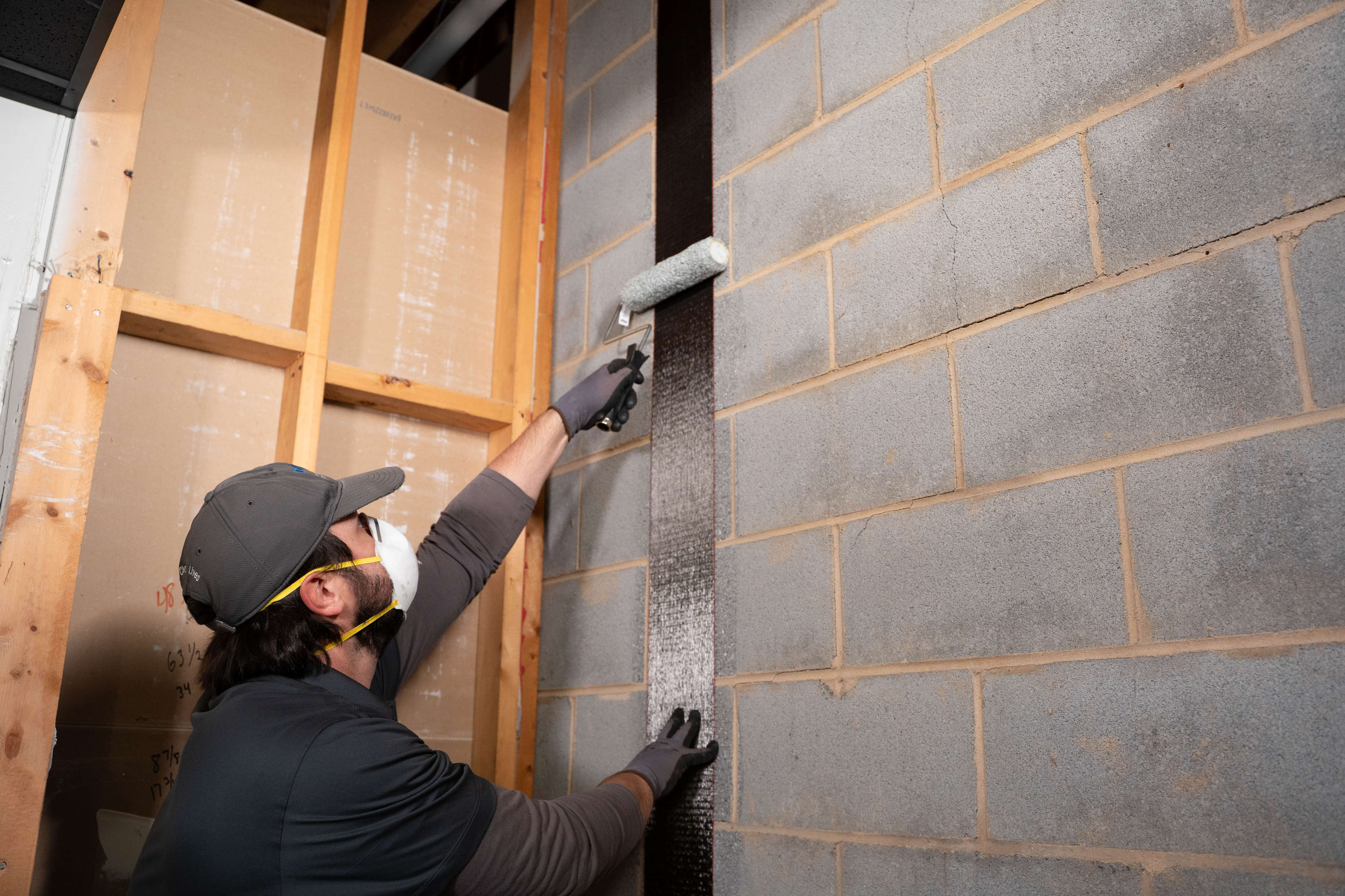 crew installing carbon fiber on basement wall