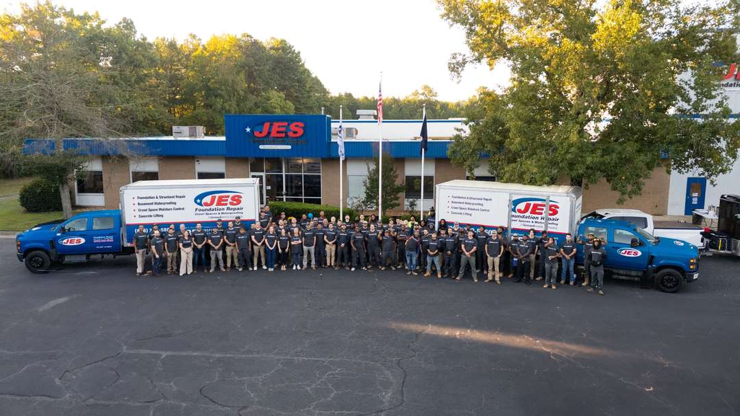 JES employees standing by company trucks outside an office