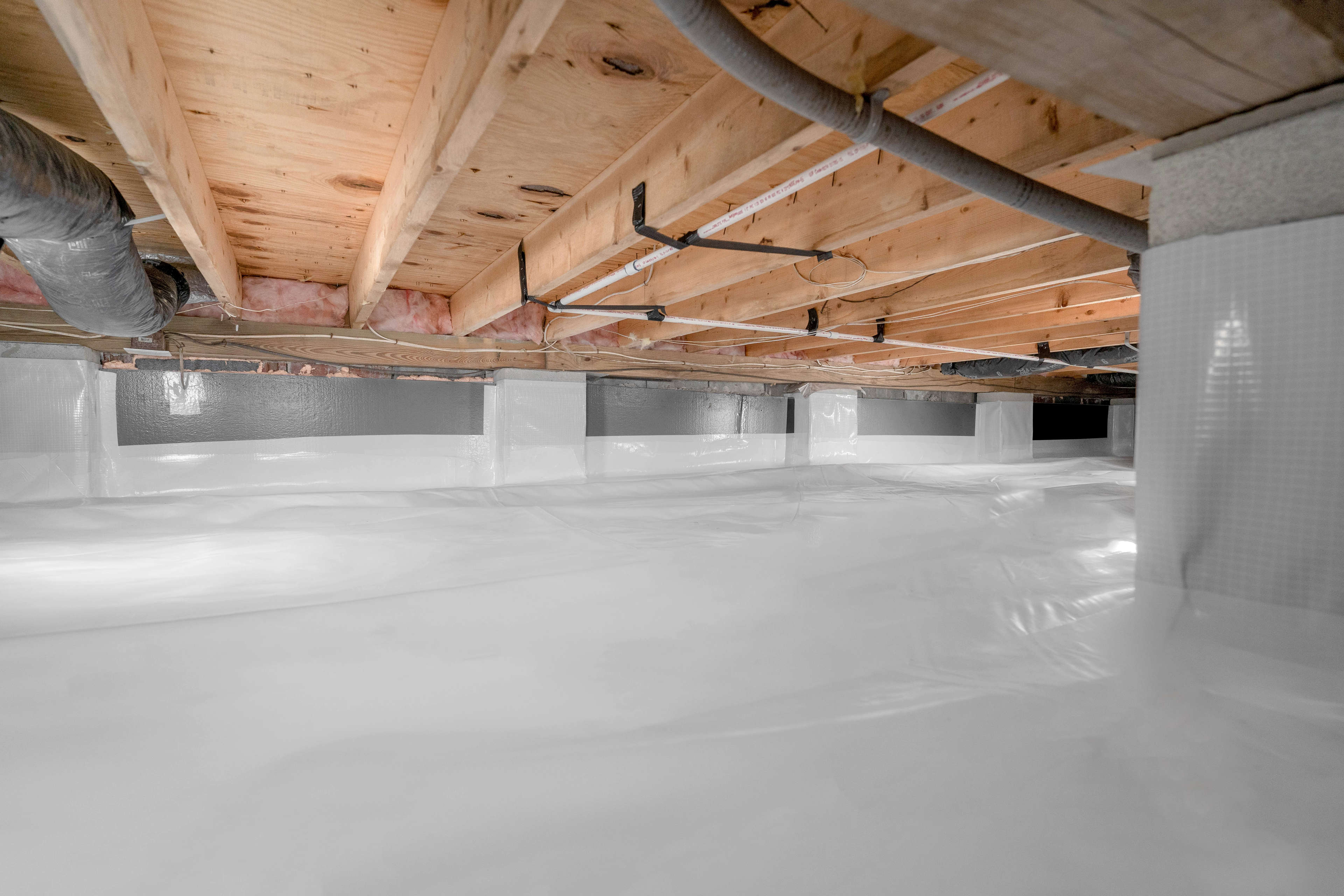 crawl space encapsulated with a vapor barrier and insulation panels