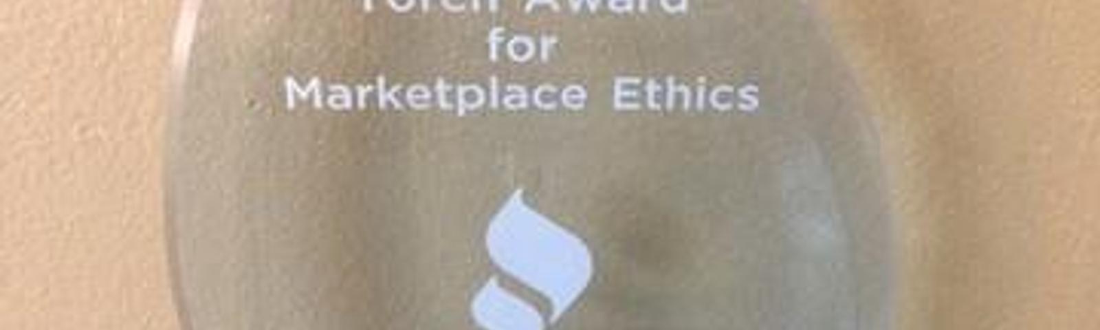 Glass award inscribed with "2014 Torch Award for Marketplace Ethics" from BBB, given to Alpha Foundation Specialists.