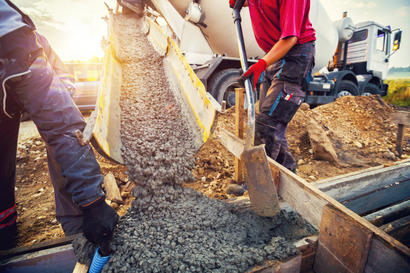A concrete contractor’s team pours concrete at a construction site.