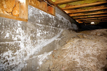 A typical crawl space under a home with mold growing on the walls