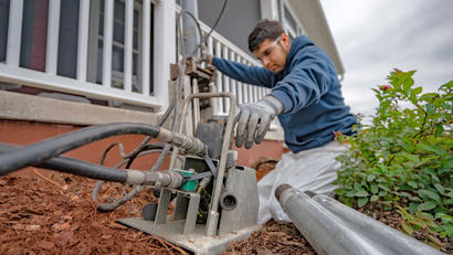 Alpha crew member installing pier at porch.