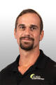 Smiling person in a black shirt with "Alpha Foundations" logo on a light background.